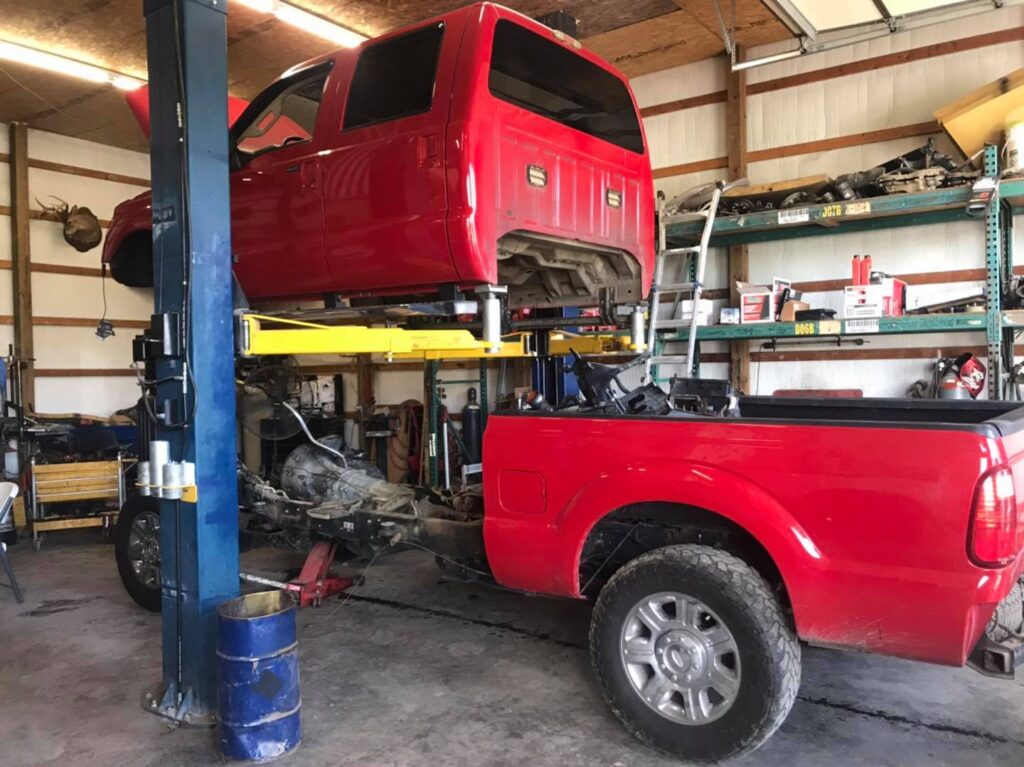 Ford Super Duty diesel cab lifted off frame for engine and transmission repair at Say-When Motorsports in Austin, Arkansas