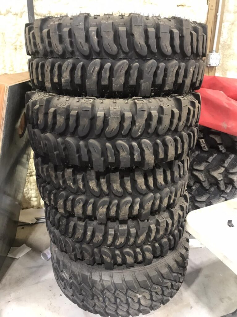 Stack of aggressive mud-terrain off-road tires at Say When Motorsports in Cabot, Arkansas