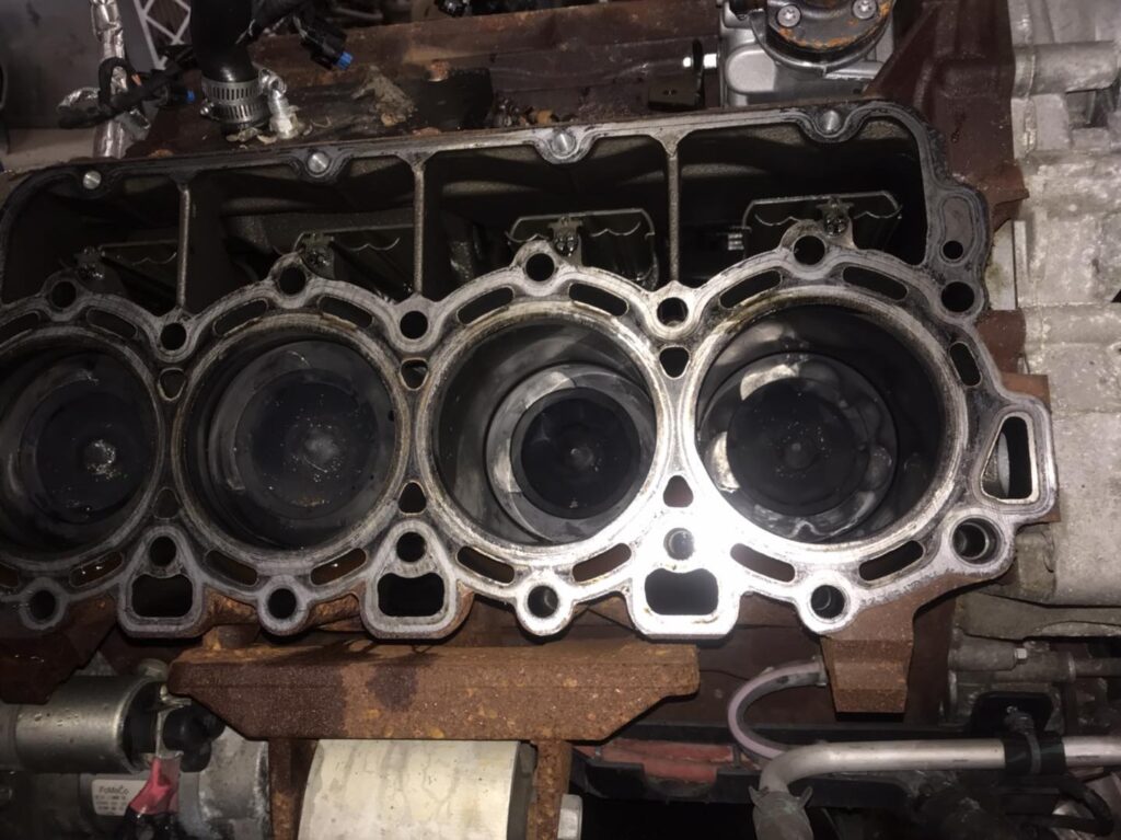 Diesel engine block with exposed pistons and cylinders during teardown at Say When Motorsports